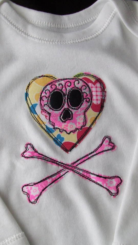 Even the tiniest of tots can look uber cool - Appliqued  baby bodysuit featuring a sugar skull and crossbones design.